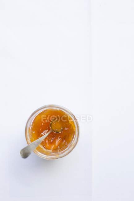 Engarrafamento de damasco em vidro com colher — Fotografia de Stock