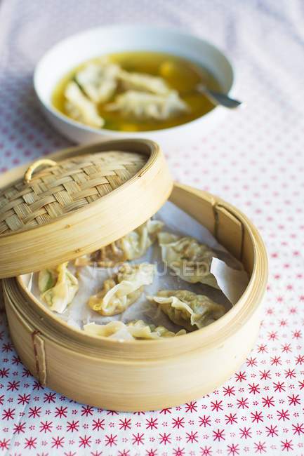 Elevated view of clear ginger broth with steamed dumplings in a steamer — Stock Photo