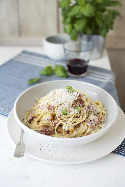 Spaghetti alla carbonara con basilico fresco — Foto stock