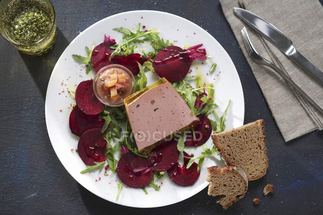 Terrine de foie d'oie sur betterave sur plaque blanche sur table — Photo de stock
