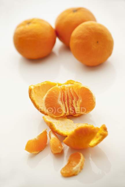 Ganze und geschälte reife Mandarinen — Stockfoto