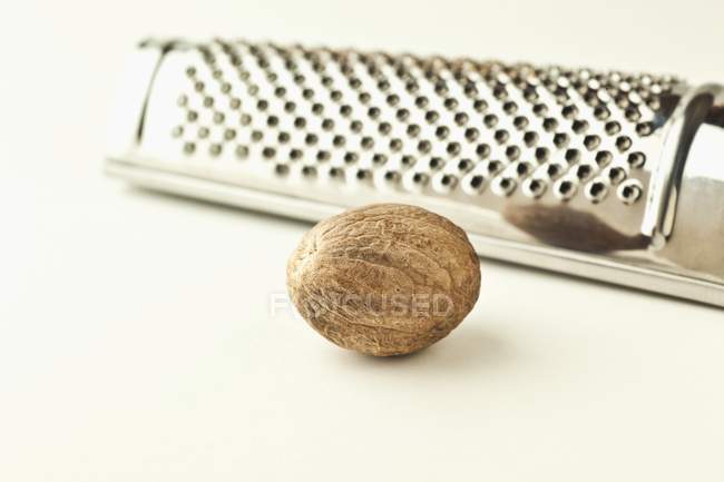 Raw nutmeg with grater — Stock Photo