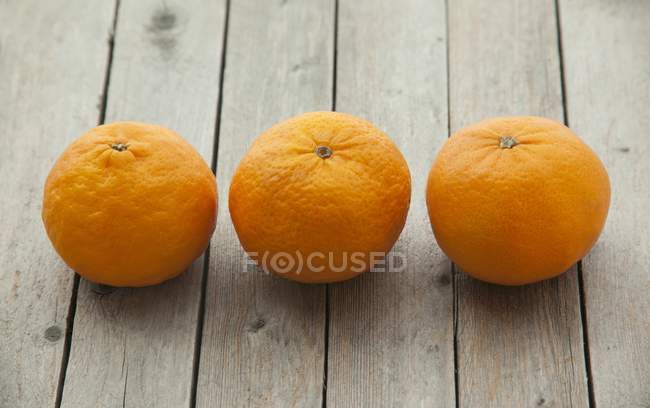 Ripe mandarins on a wooden surface — Stock Photo