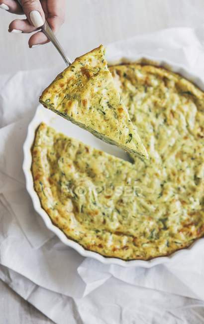 Courgette frittata with herbs, sliced over white towel — Stock Photo
