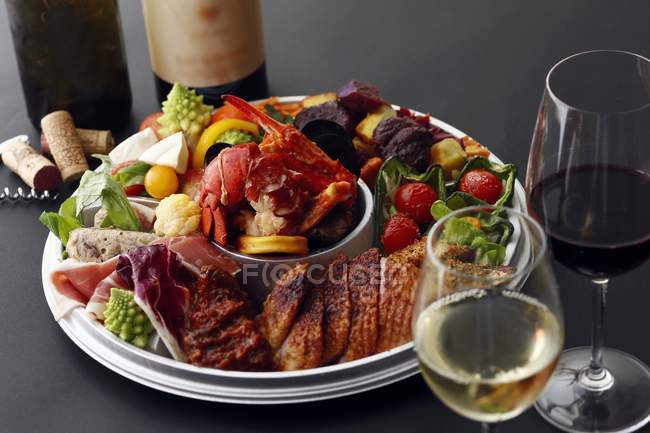Closeup view of an appetizer platter served with wine — Stock Photo
