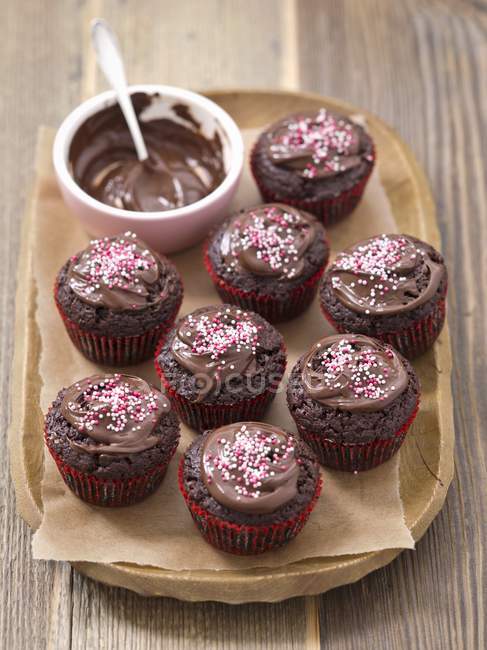 Magdalenas con salsa de chocolate y salpicaduras de azúcar - foto de stock