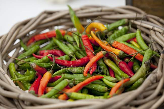Colored Fresh chillis in a straw basket — Stock Photo