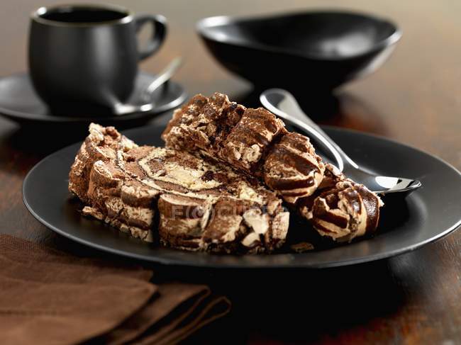 Вид крупным планом на два ломтика шоколада Рулада на черной тарелке — стоковое фото