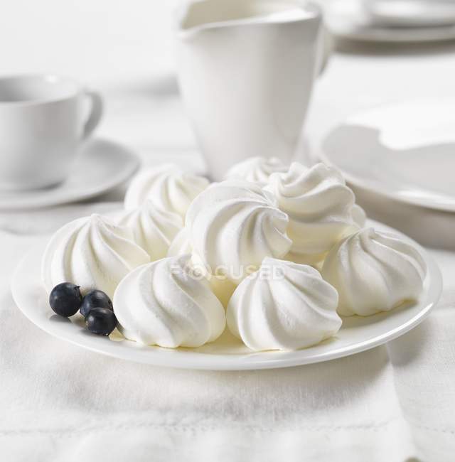 Meringues and blueberries on plate — Stock Photo