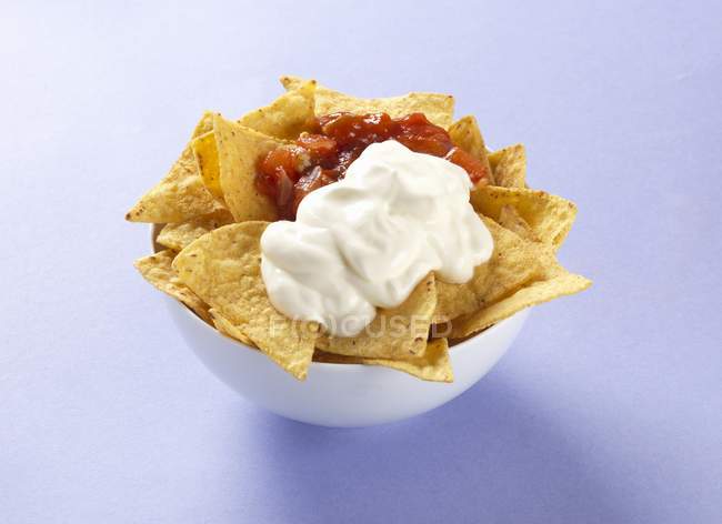 Tortilla crisps with salsa and sour cream — Stock Photo