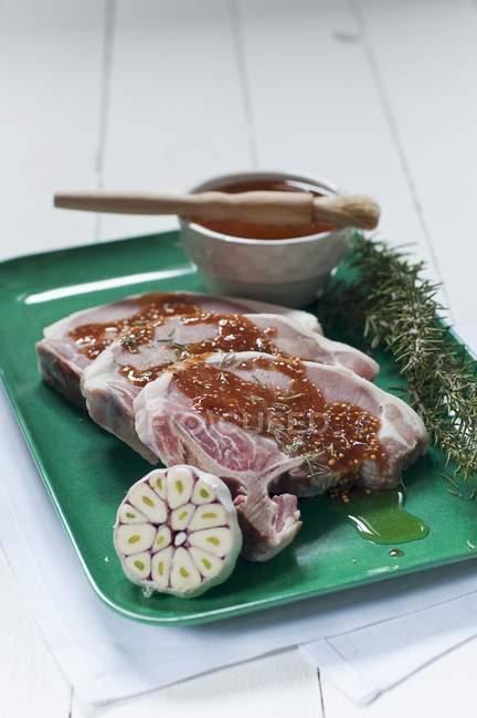 Chuletas de cerdo crudas con adobo de mostaza - foto de stock