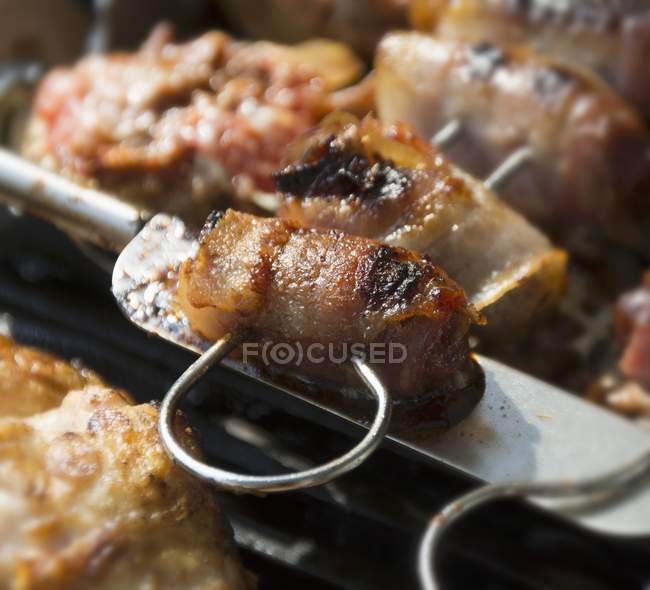Vista close-up de figos embrulhados em bacon em uma grade — Fotografia de Stock