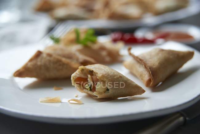 Nahaufnahme ganzer und gebissener Samosas auf dem Teller — Stockfoto