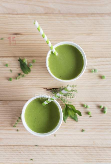 Cups of cold pea soup in bowls — Stock Photo