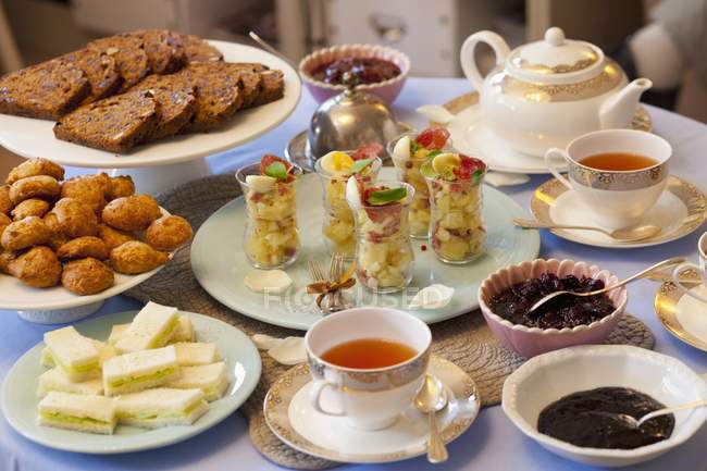 Vista sopraelevata di tavolo con vari piatti, una teiera e tazze da tè — Foto stock