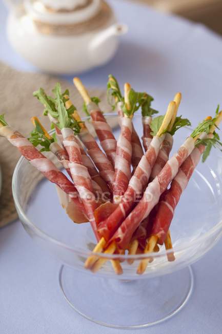 Breadsticks with rocket and ham — Stock Photo
