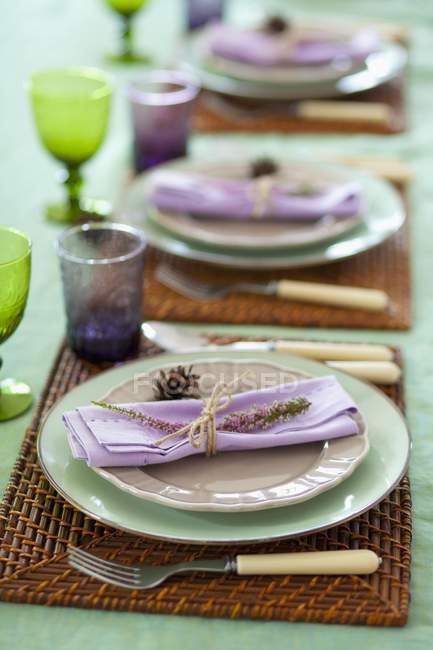 Vue surélevée d'une table posée avec des serviettes lilas décorées de fleurs — Photo de stock