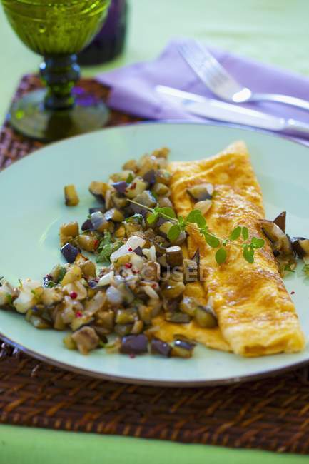 Aubergine omelettes on blue plate over table — Stock Photo