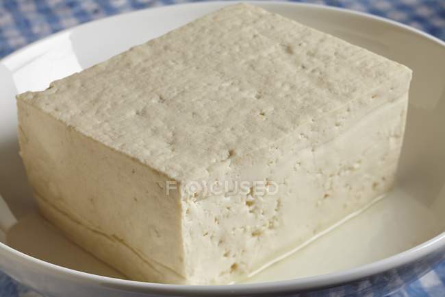 Vue rapprochée du morceau de fromage Tofu dans un bol blanc — Photo de stock