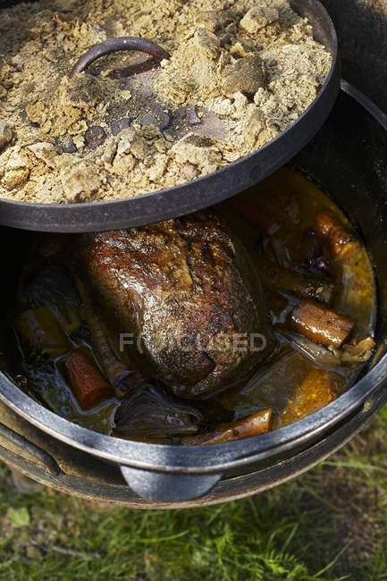 Primer plano de cerdo asado estofado con verduras que se preparan en un horno holandés - foto de stock