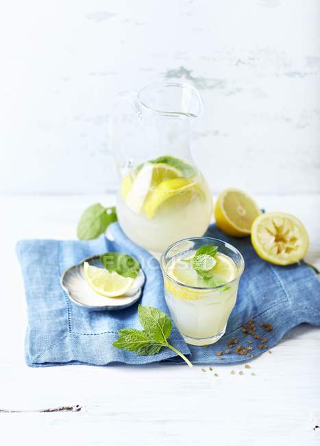 Lemonade with lemon wedges and mint — Stock Photo