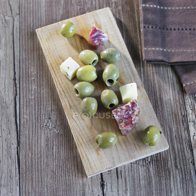 Olives vertes sur planche de bois — Photo de stock