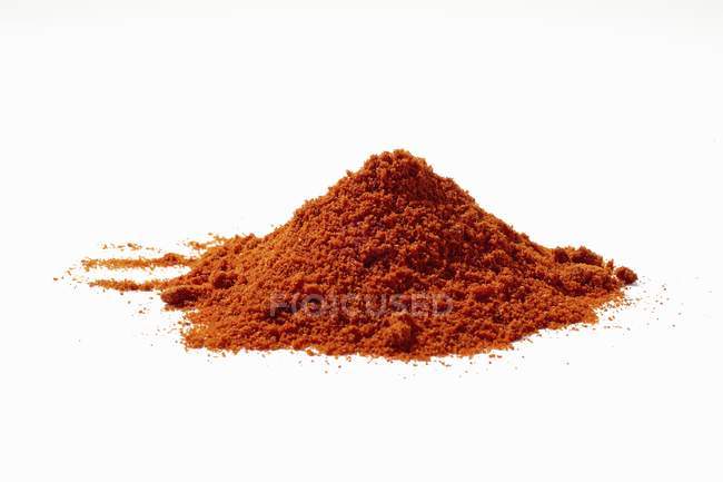 Closeup view of red allspice powder heap on white surface — Stock Photo