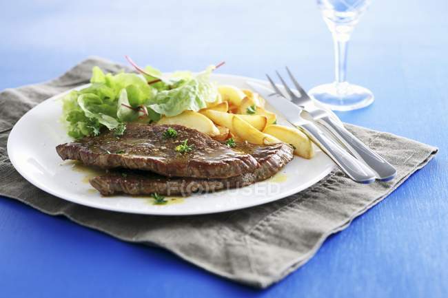 Beef steaks with lettuce and apple — Stock Photo