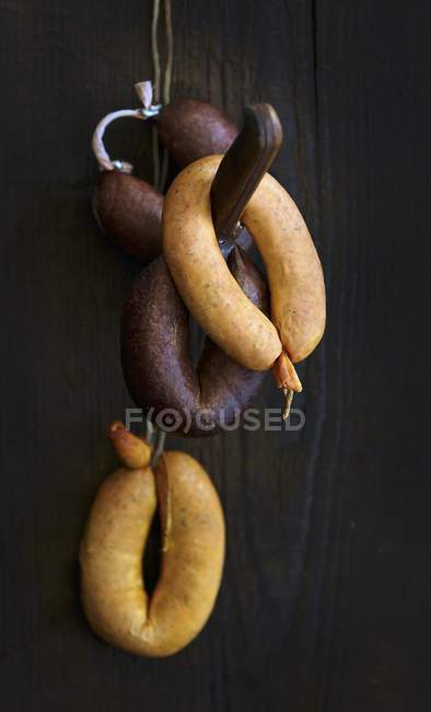 Sausages hanging on hook — Stock Photo