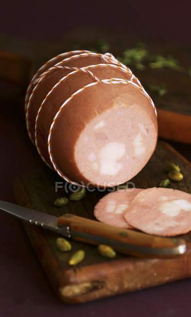 Partly sliced Mortadella and pistachios — Stock Photo