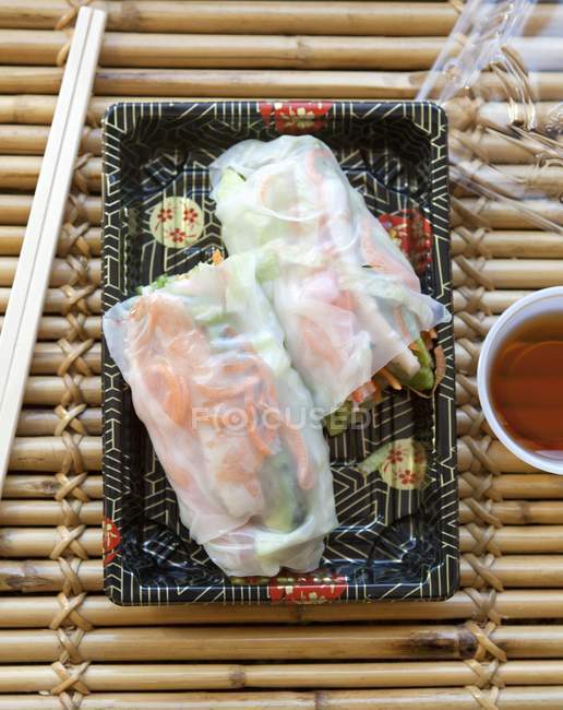 Top view of spring rolls on a patterned dish with chopsticks — Stock Photo