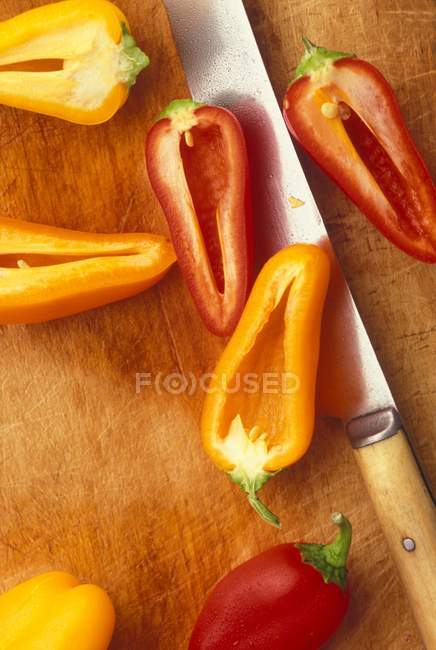 Mini pimentas vermelhas e amarelas cortadas pela metade — Fotografia de Stock