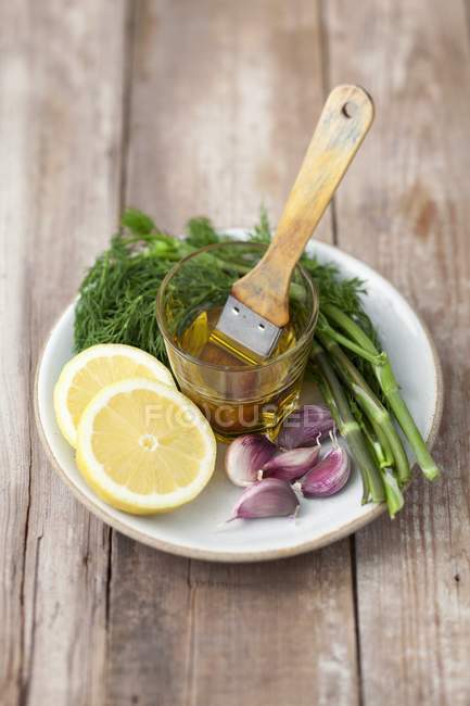 Ingredients for grilled fish on white plate with cup and whisk — Stock Photo