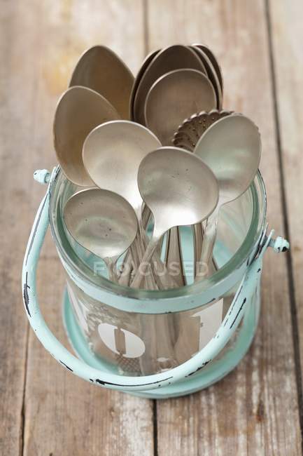 Closeup elevated view of old spoons in a glass container — Stock Photo