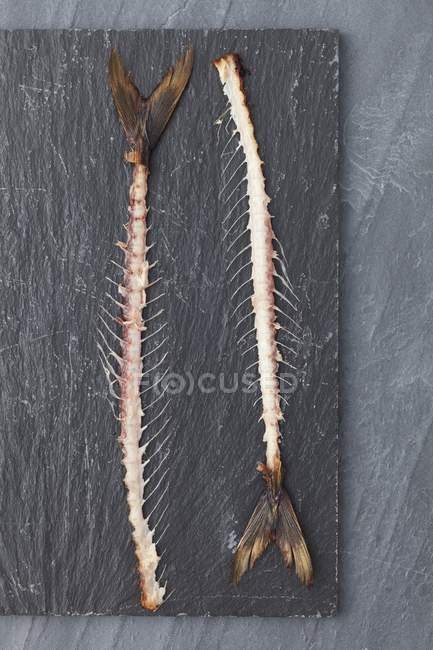 Vue de dessus de deux carcasses de maquereau sur un tableau noir — Photo de stock