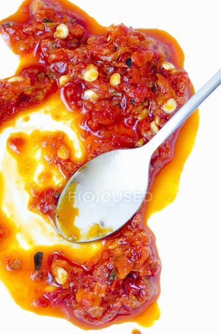 Salsa de pimenta da Calábria com uma colher no fundo branco — Fotografia de Stock