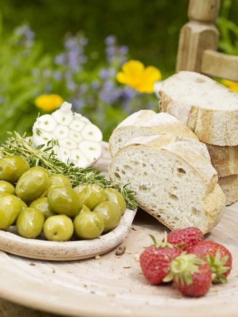 Baguette in Scheiben geschnitten mit Oliven und Erdbeeren — Stockfoto