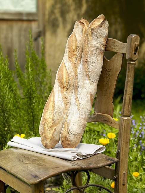 Baguettes on wooden chair — Stock Photo