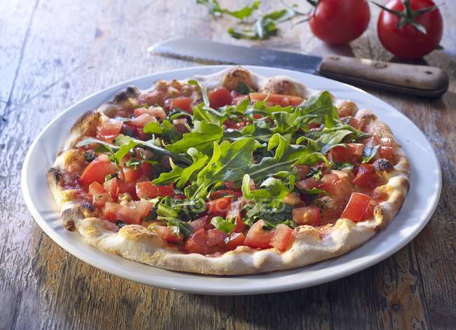 Pizza with fresh tomatoes and arugula — Stock Photo