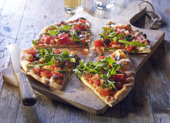 Pan de pizza con tomates y cohete - foto de stock