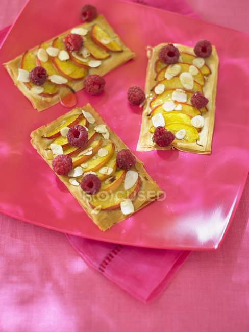 Puff pastries with peaches and raspberries — Stock Photo