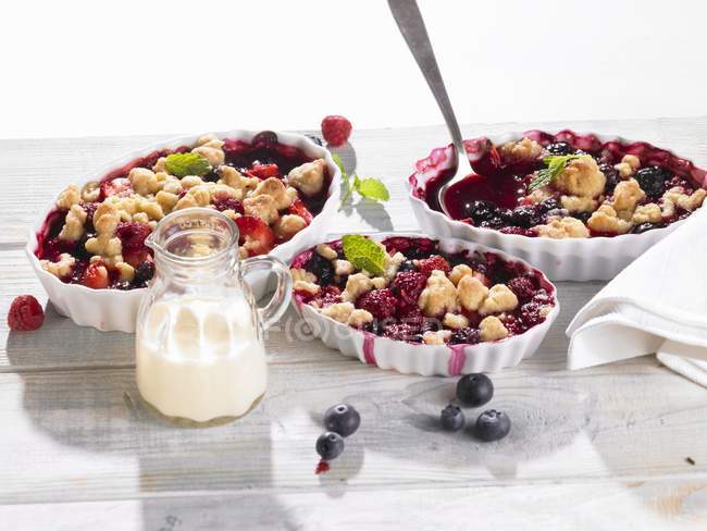 Closeup view of berry crumbles with cream — Stock Photo