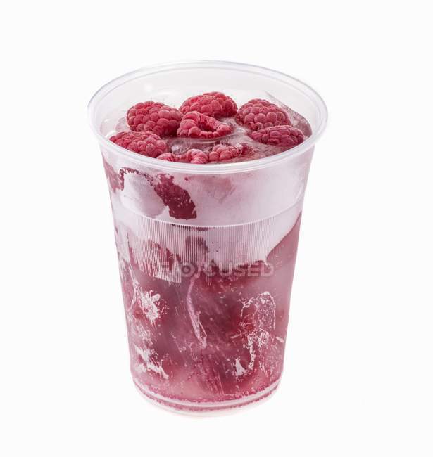 Замороженная малина в пластиковой чашке — стоковое фото