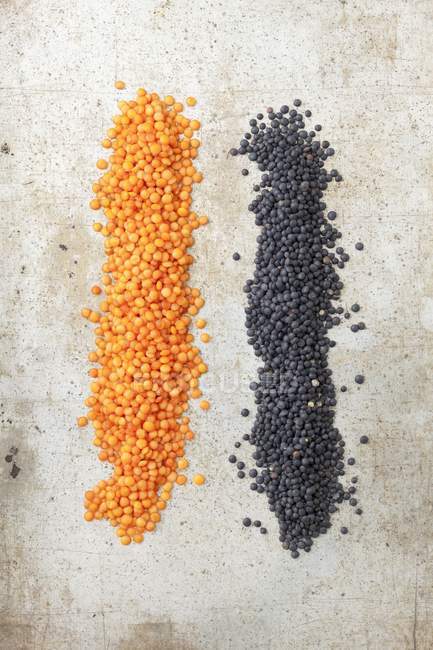Top view of red and black lentils on a stone surface — Stock Photo