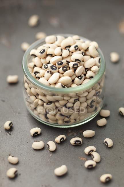 A jar of black eyed peas in glass jar over grey surface — Stock Photo
