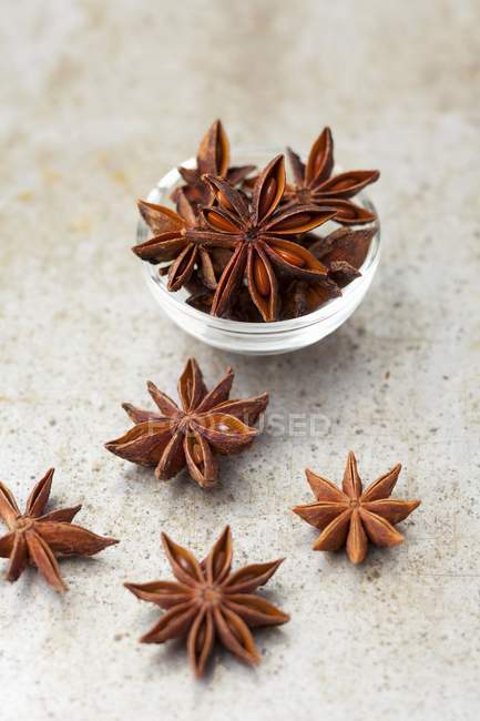 Closeup view of star anise in small bowl and on stone surface — Stock Photo