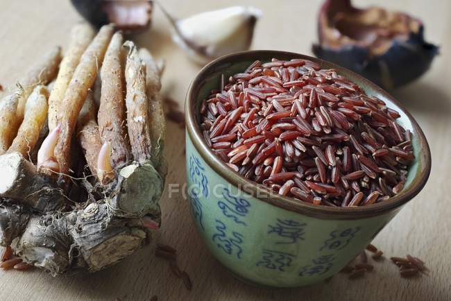 Fingerroots and bowl of red rice — Stock Photo