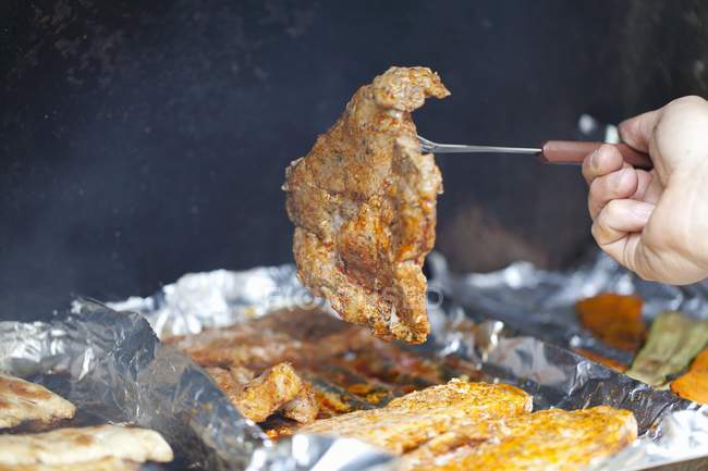 Man grilling pork steak — Stock Photo