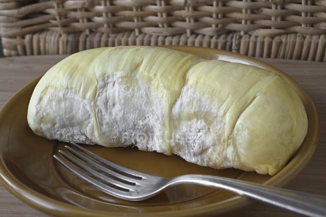 Closeup view of peeled durian piece on a plate — Stock Photo