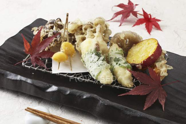 Vegetable tempuras on black desk over white surface — Stock Photo
